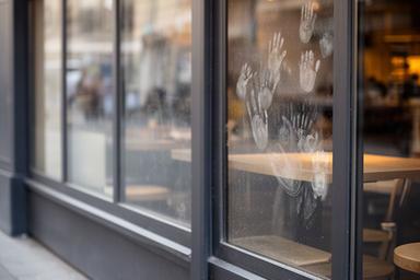 Cafe street windows showing fingerprints and road dust before a planned clean